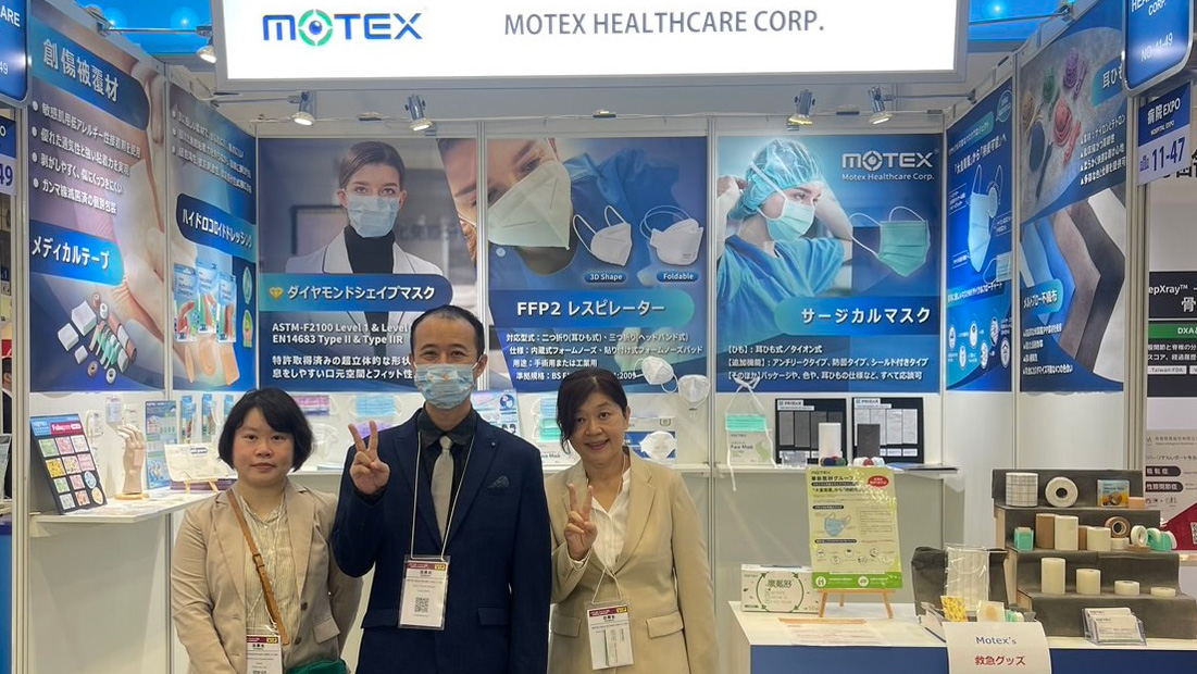 Group photo of the Motex team with the General Manager, Deputy Manager, and Specialist in front of the product display at MEDICAL JAPAN 2024.